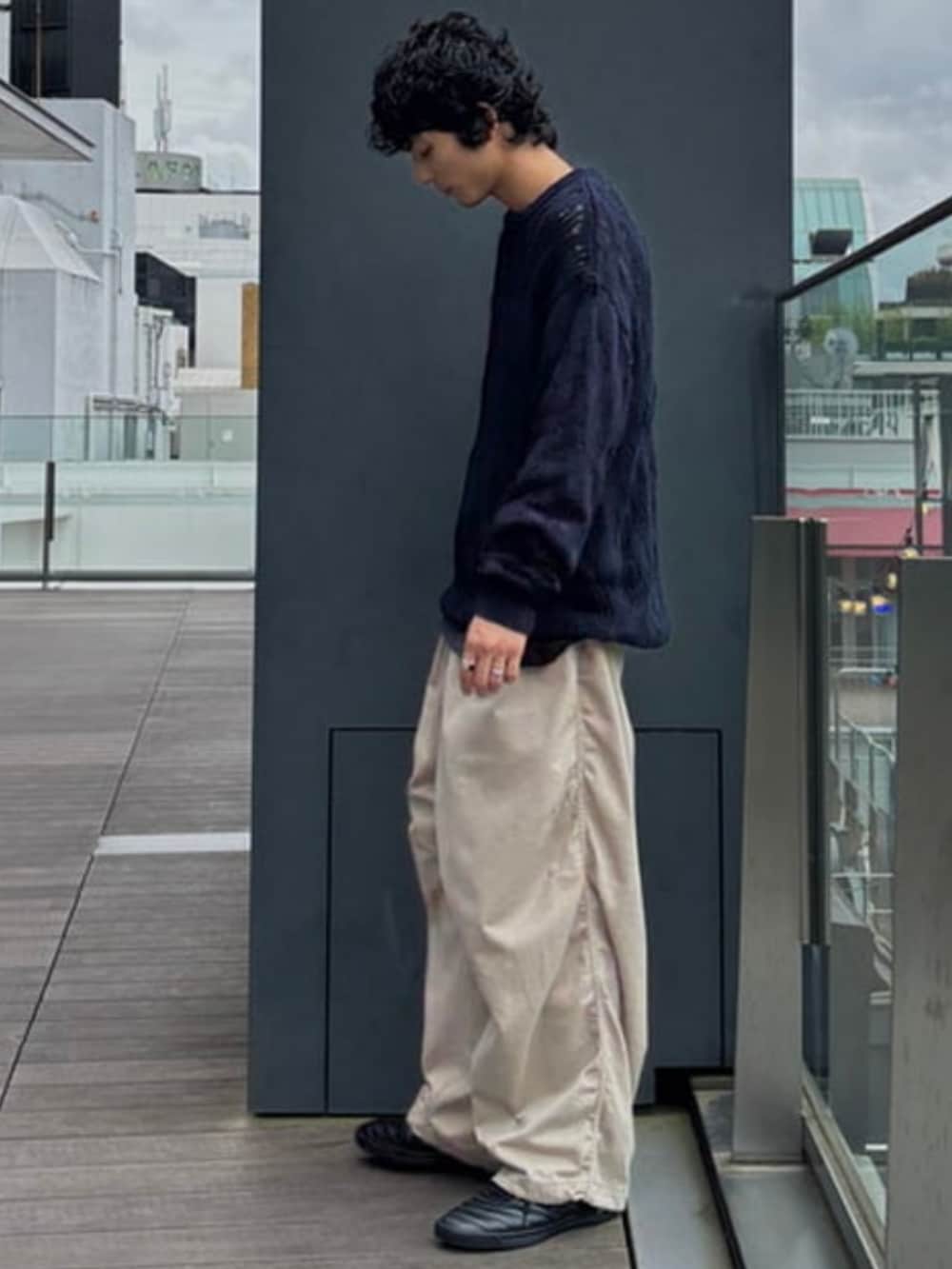 ブルー系のニット/セーター、ベージュ系のチノパンツを着用したメンズの夏コーディネートの2枚目の写真