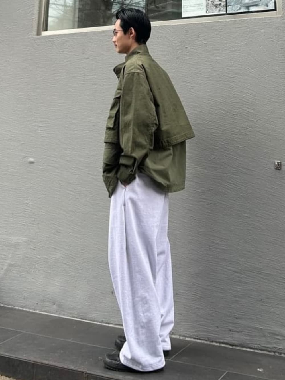 グレー系のその他パンツ、グリーン系のミリタリージャケットを着用したメンズの冬コーディネートの2枚目の写真
