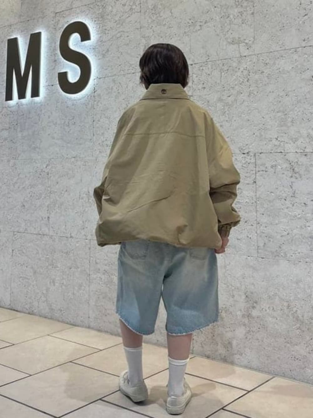 ブルー系のデニムパンツ、ベージュ系のブルゾンを着用したレディースの春コーディネートの3枚目の写真