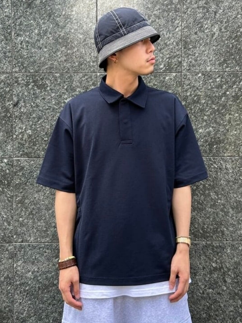 ブルー系のポロシャツ、ブルー系のハットを着用したメンズの夏コーディネートの2枚目の写真