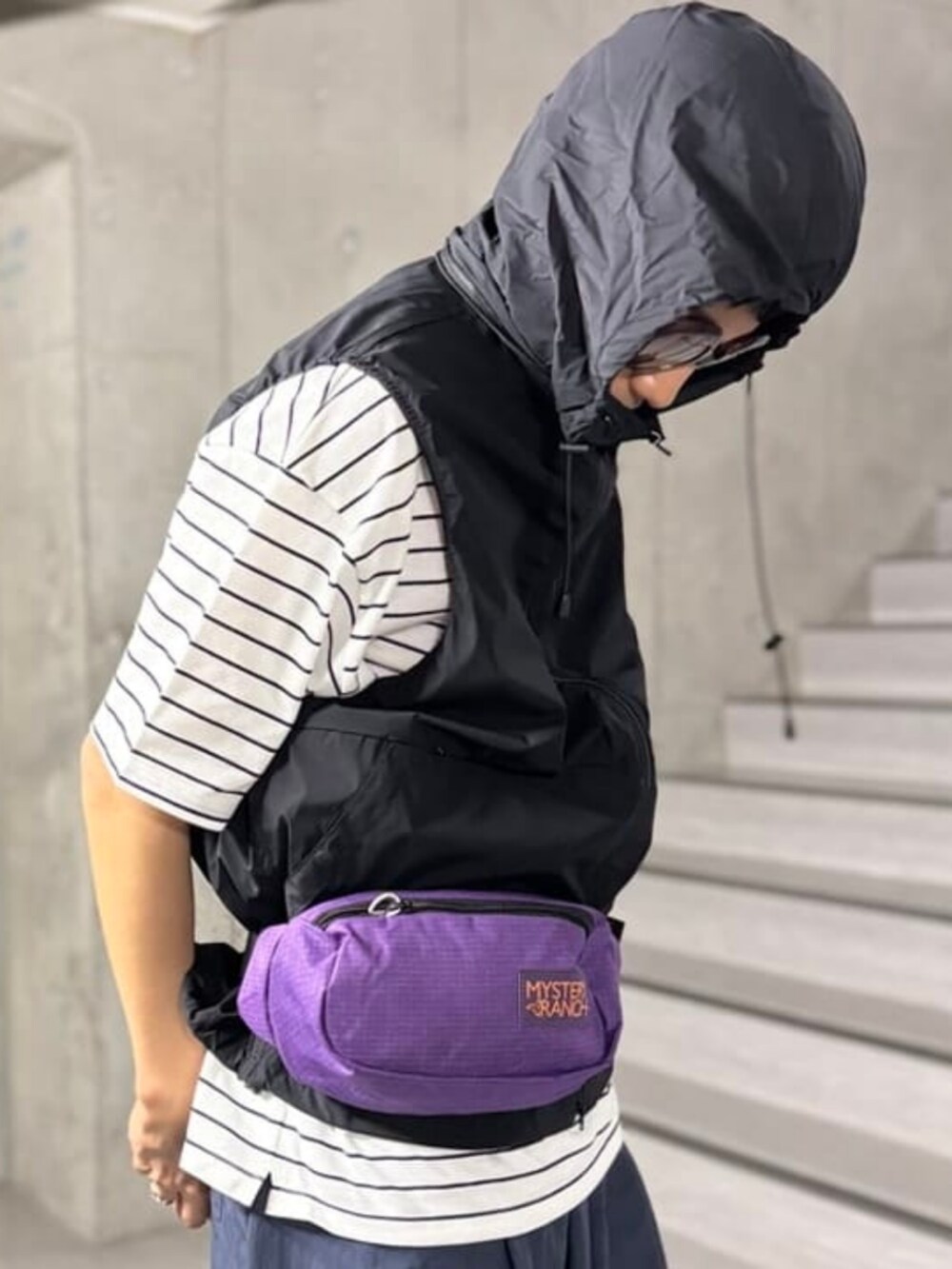 ホワイト系のTシャツ/カットソー、ブラック系のベスト、ブルー系のデニムパンツを着用したメンズの春コーディネートの3枚目の写真