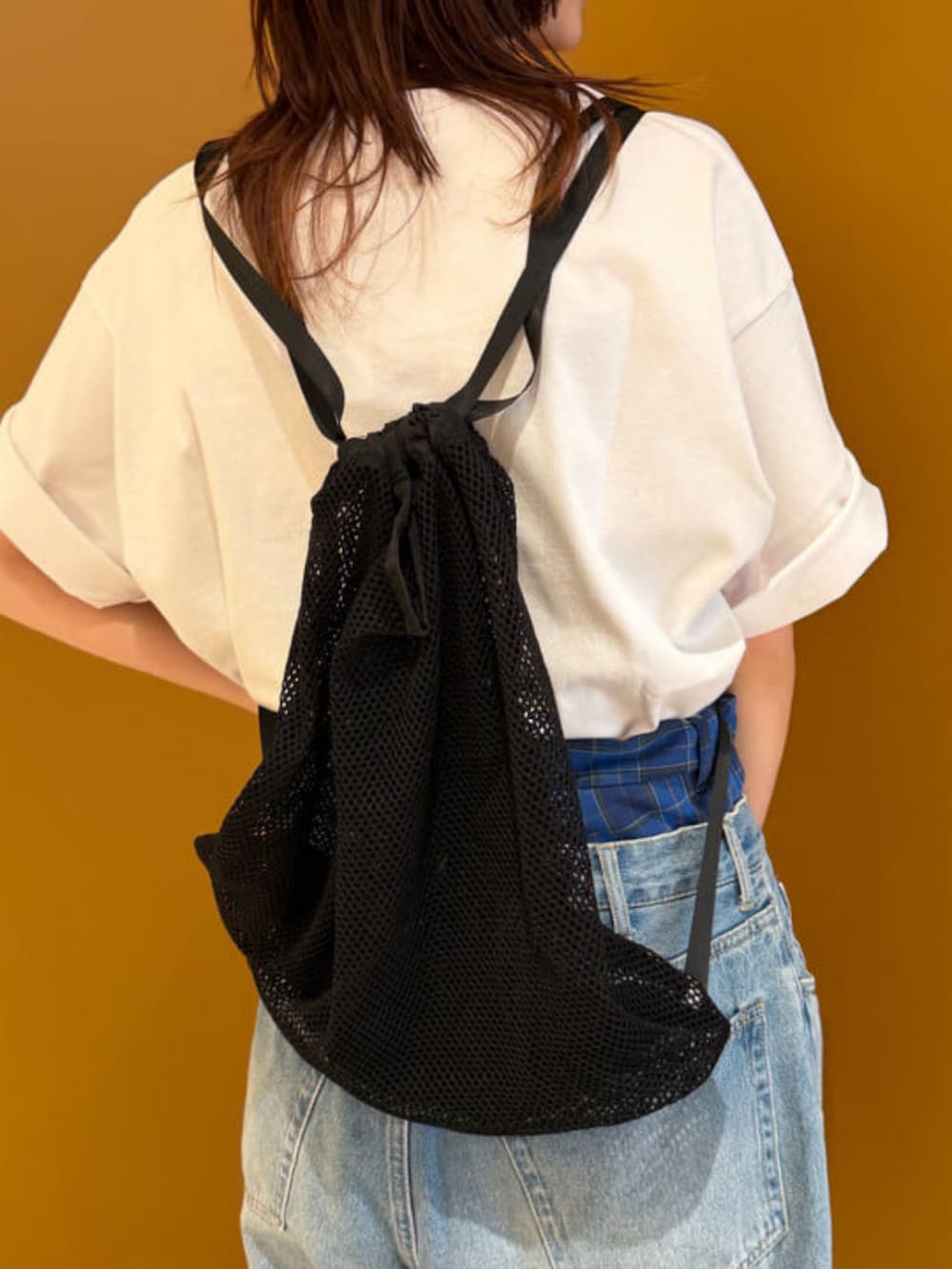 ホワイト系のTシャツ/カットソー、ブルー系のその他パンツ、ブラック系のバックパック/リュックを着用したレディースの春コーディネートの6枚目の写真