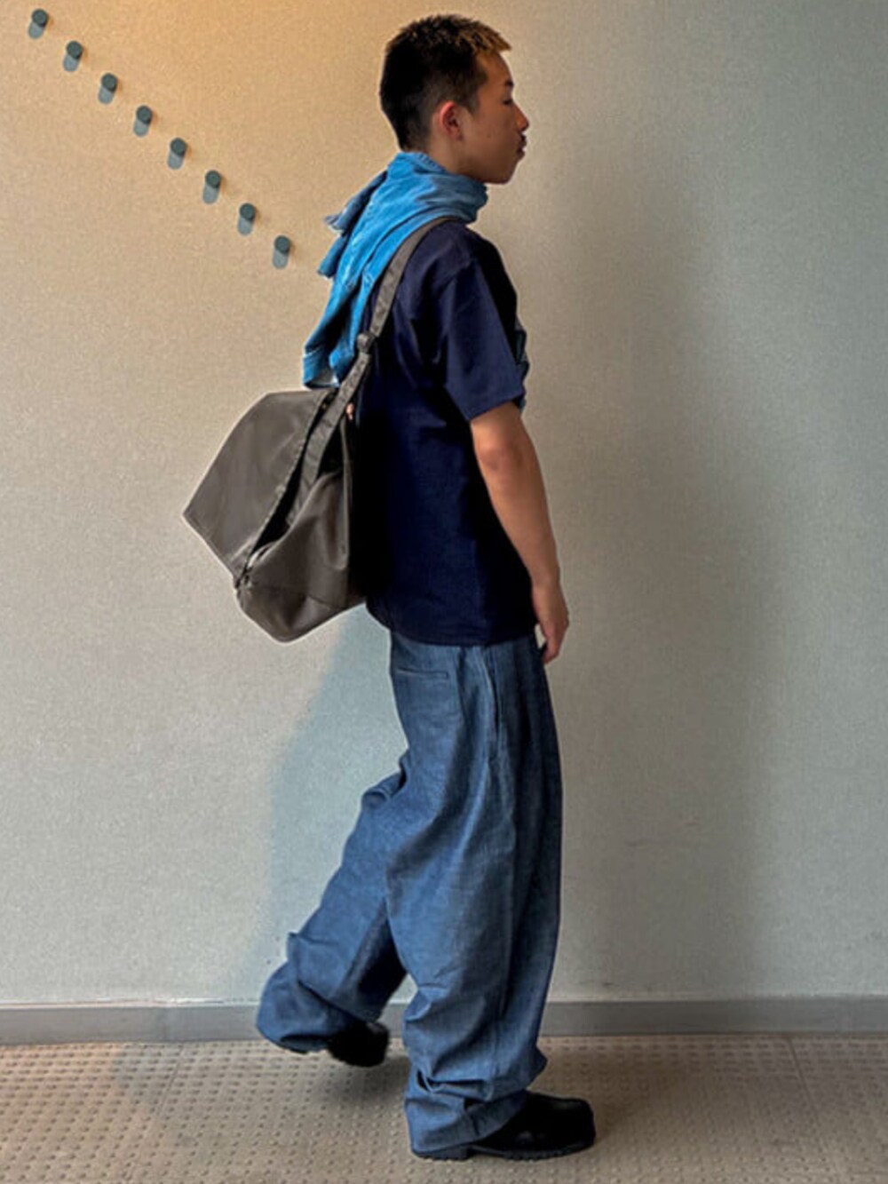 ブルー系のTシャツ/カットソー、ブルー系のスラックス、グリーン系のショルダーバッグを着用したメンズの夏コーディネートの2枚目の写真