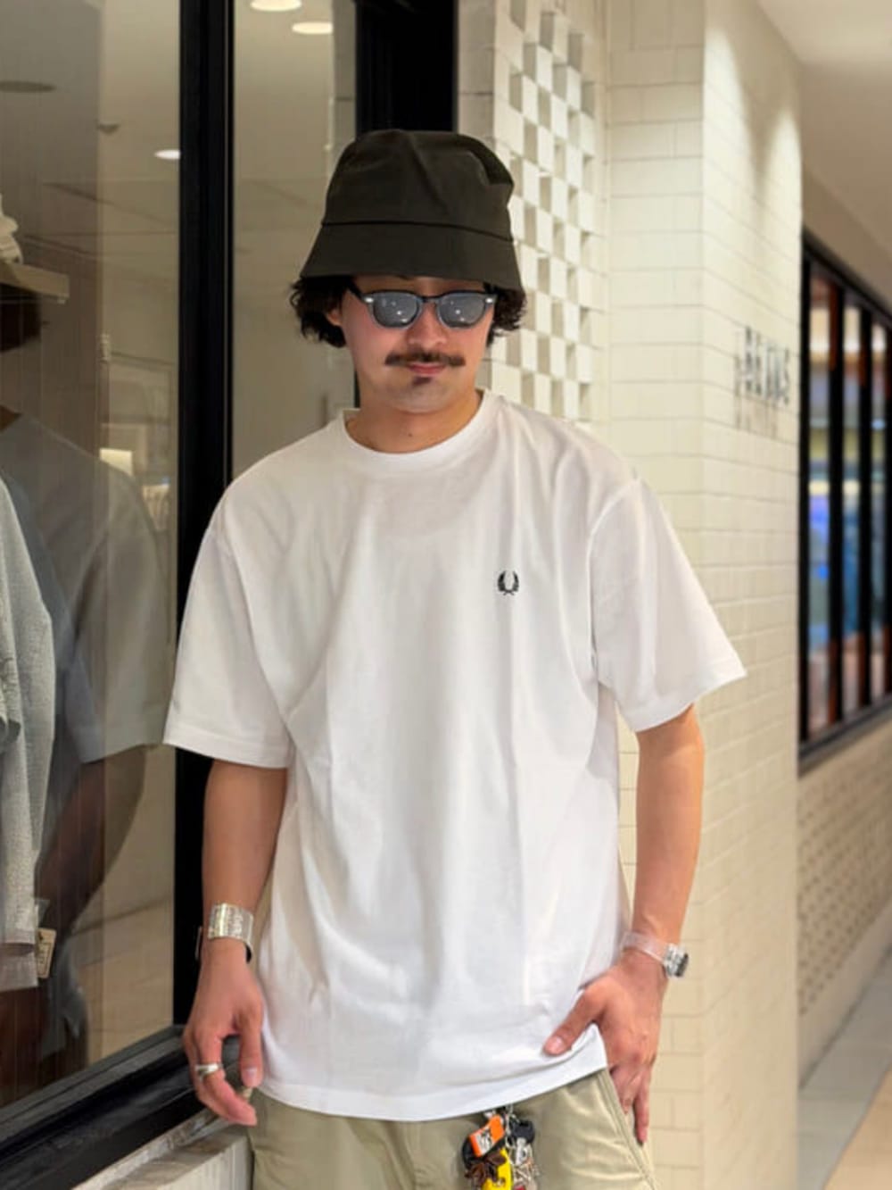 ホワイト系のTシャツ/カットソー、グリーン系のハットを着用したメンズの夏コーディネートの2枚目の写真