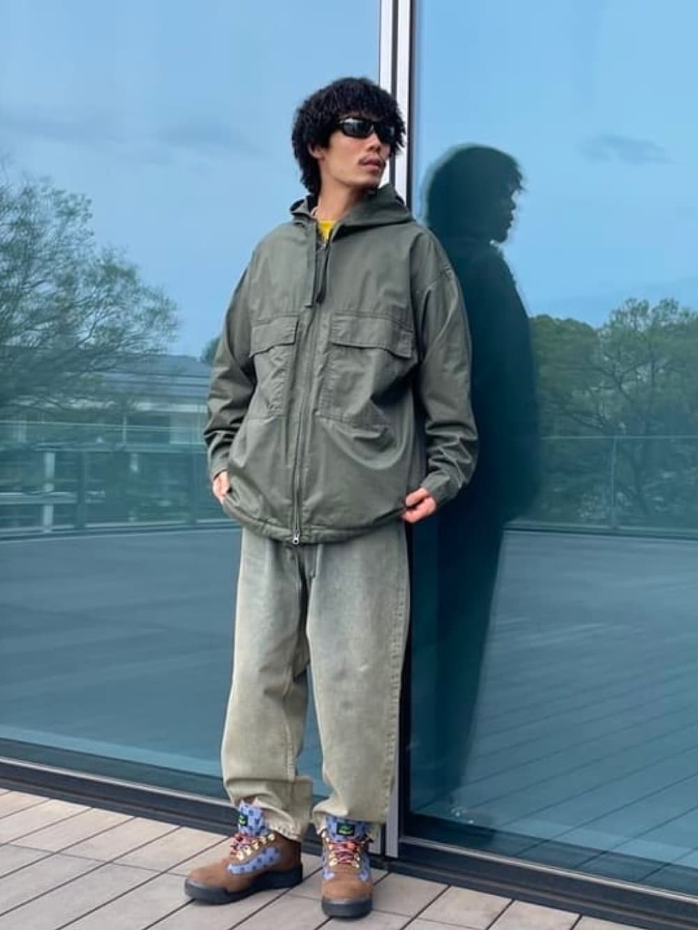 グリーン系のミリタリージャケット、ブルー系のデニムパンツを着用したメンズの春コーディネートの2枚目の写真