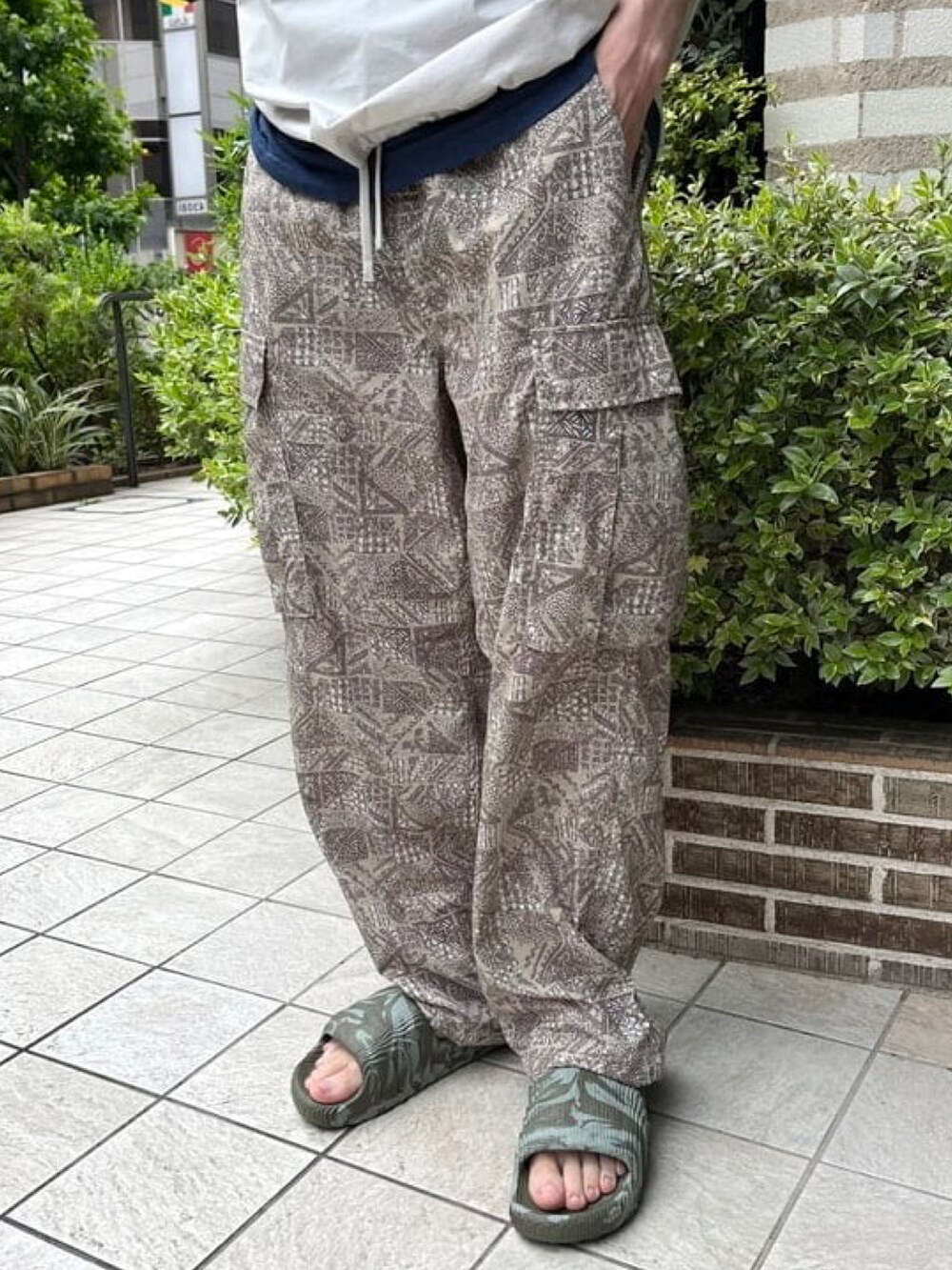 グレー系のポロシャツ、ベージュ系のカーゴパンツ、グリーン系のサンダルを着用したメンズの夏コーディネートの5枚目の写真