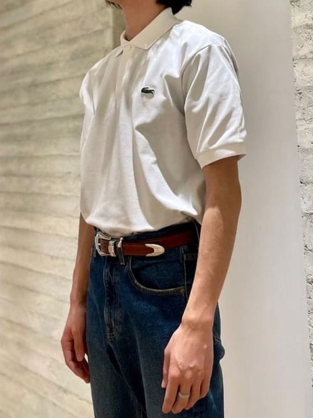 ホワイト系のポロシャツ、グリーン系のジャージ、ブルー系のデニムパンツを着用したメンズの春コーディネートの4枚目の写真