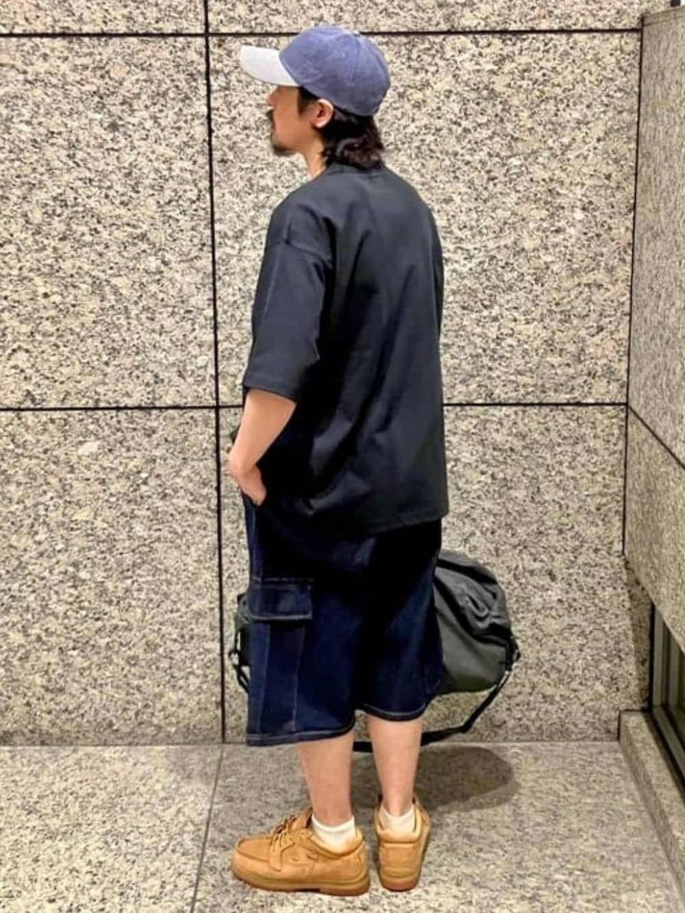 ブルー系のデニムパンツ、ブラック系のボディバッグ/ウエストポーチ、ブラック系のTシャツ/カットソーを着用したメンズの夏コーディネートの2枚目の写真