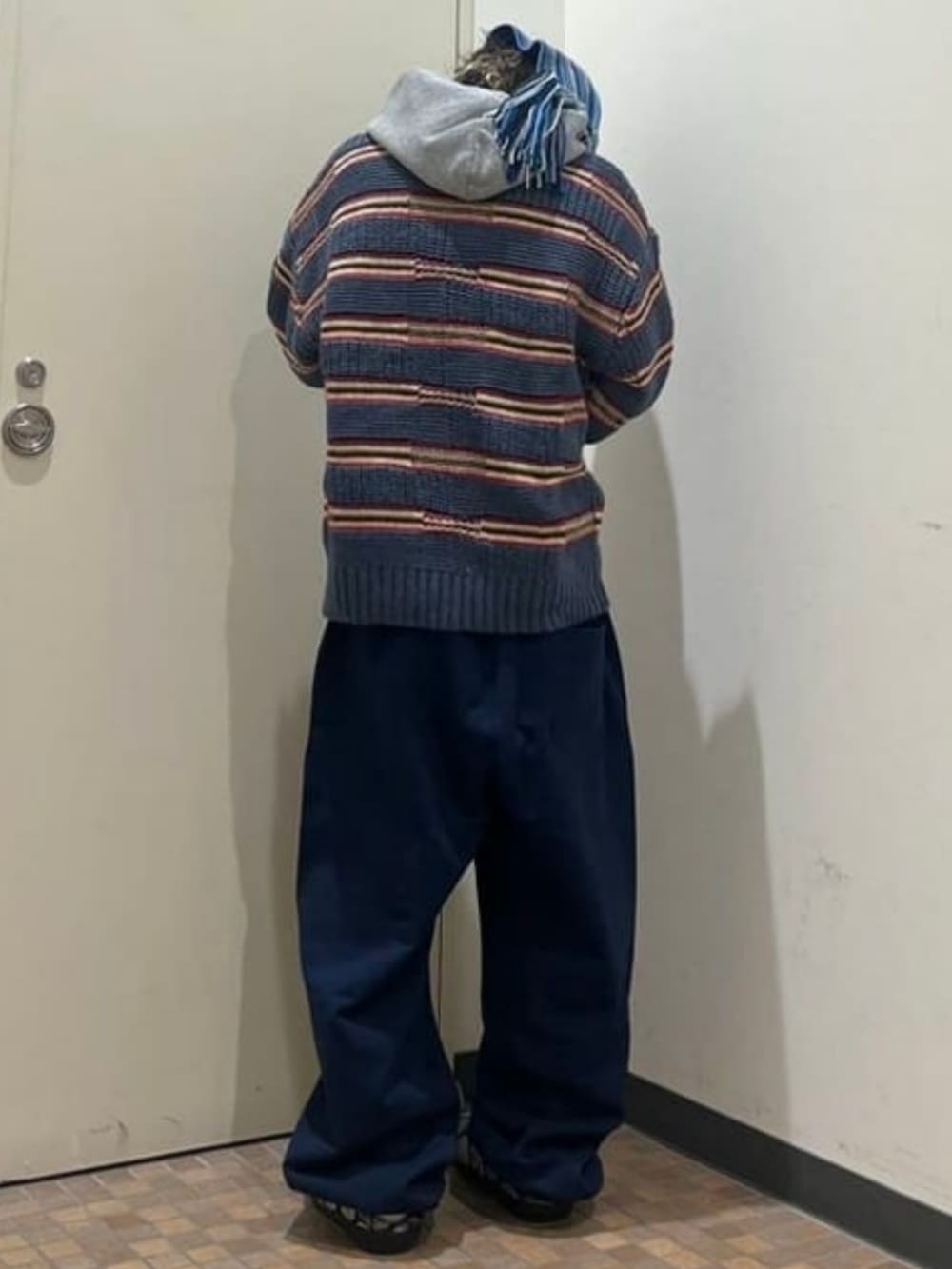 ブルー系のニット/セーター、ブルー系のスウェットパンツ、グレー系のパーカーを着用したメンズの冬コーディネートの2枚目の写真