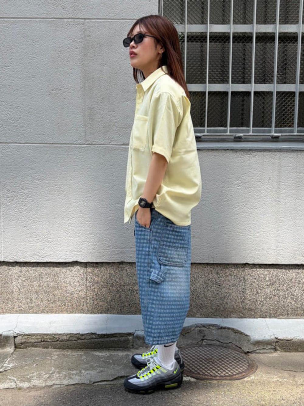 イエロー系のシャツ/ブラウス、ブルー系のその他パンツ、ブラック系のサングラスを着用したレディースの夏コーディネートの2枚目の写真