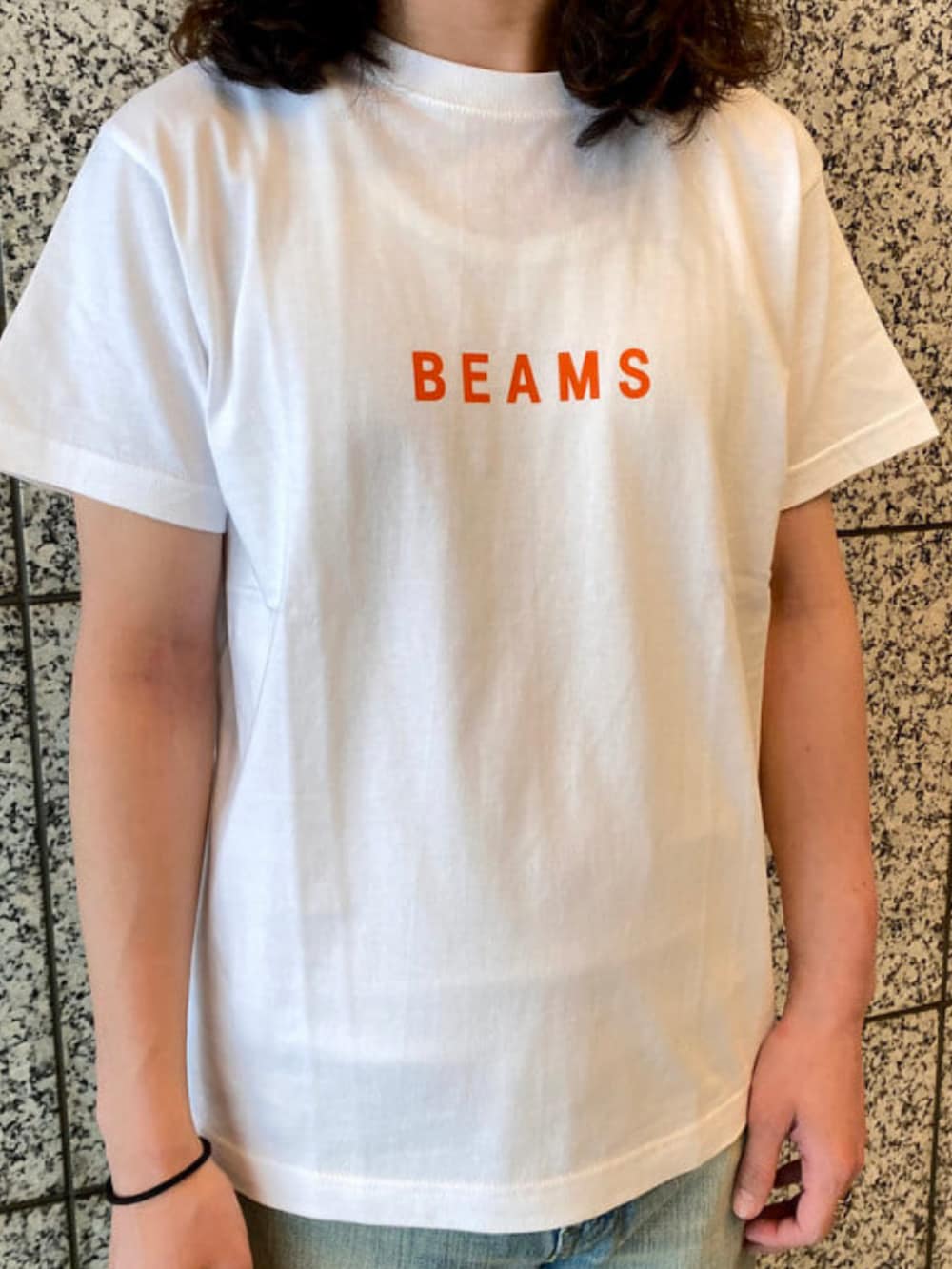 ホワイト系のTシャツ/カットソー、ブルー系のデニムパンツを着用したメンズの春コーディネートの3枚目の写真