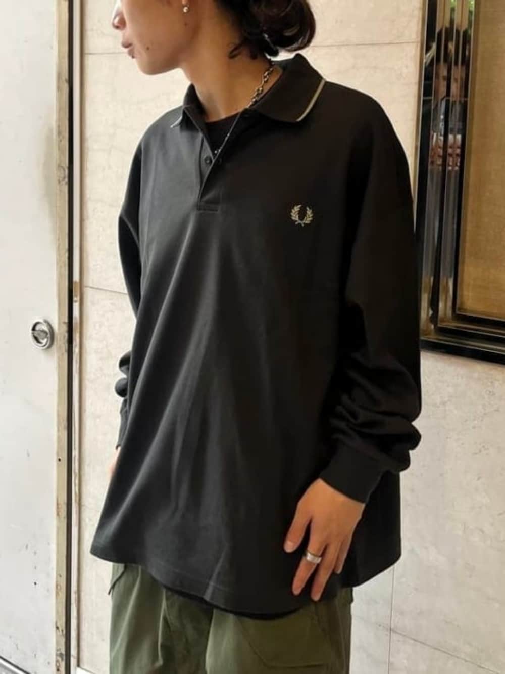 グリーン系のカーゴパンツ、グリーン系のポロシャツを着用したメンズの秋コーディネートの2枚目の写真