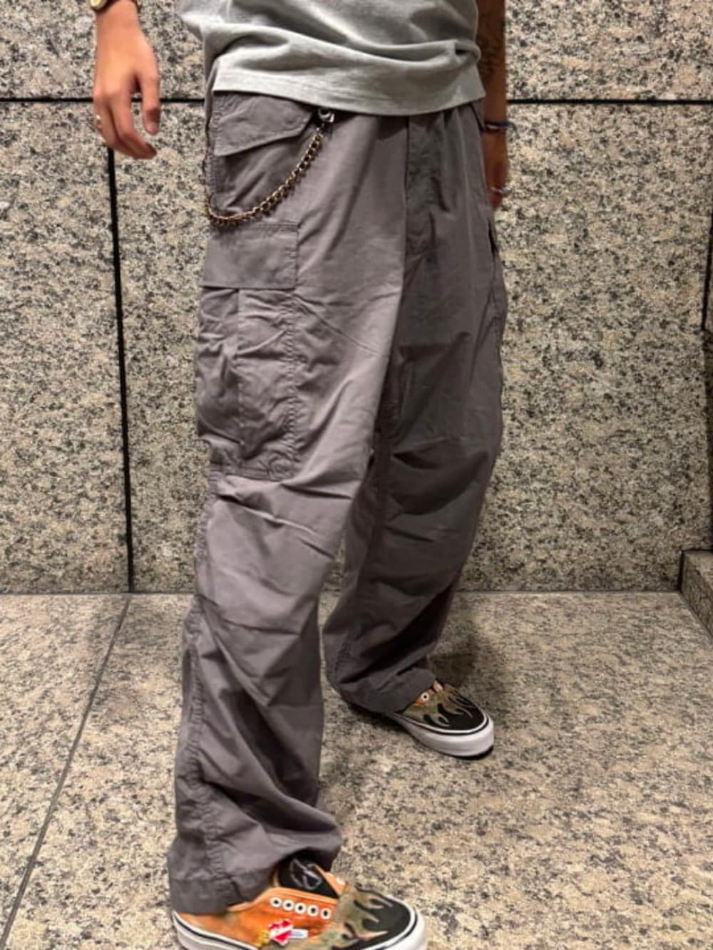 グレー系のカーゴパンツ、グレー系のポロシャツ、グリーン系のハットを着用したメンズの夏コーディネートの4枚目の写真