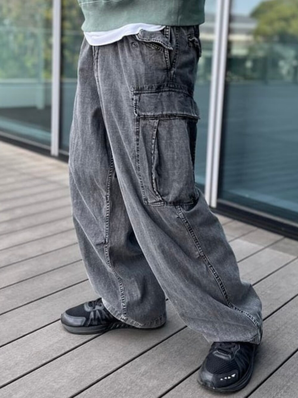 グリーン系のスウェット、ブラック系のカーゴパンツを着用したメンズの夏コーディネートの3枚目の写真