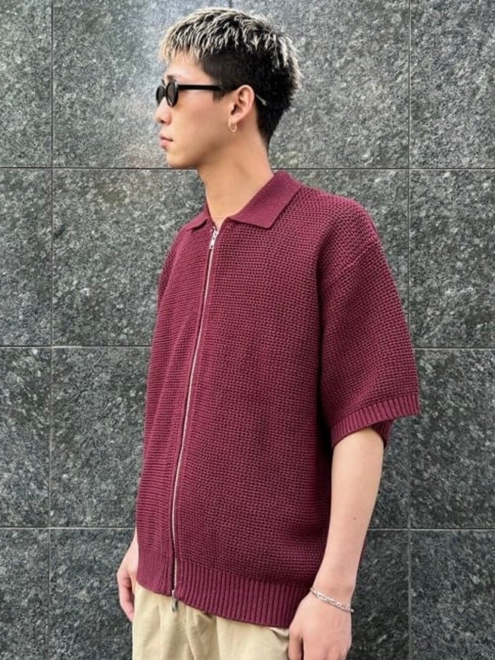 レッド系のポロシャツ、シルバー系のブレスレットを着用したメンズの春コーディネートの4枚目の写真