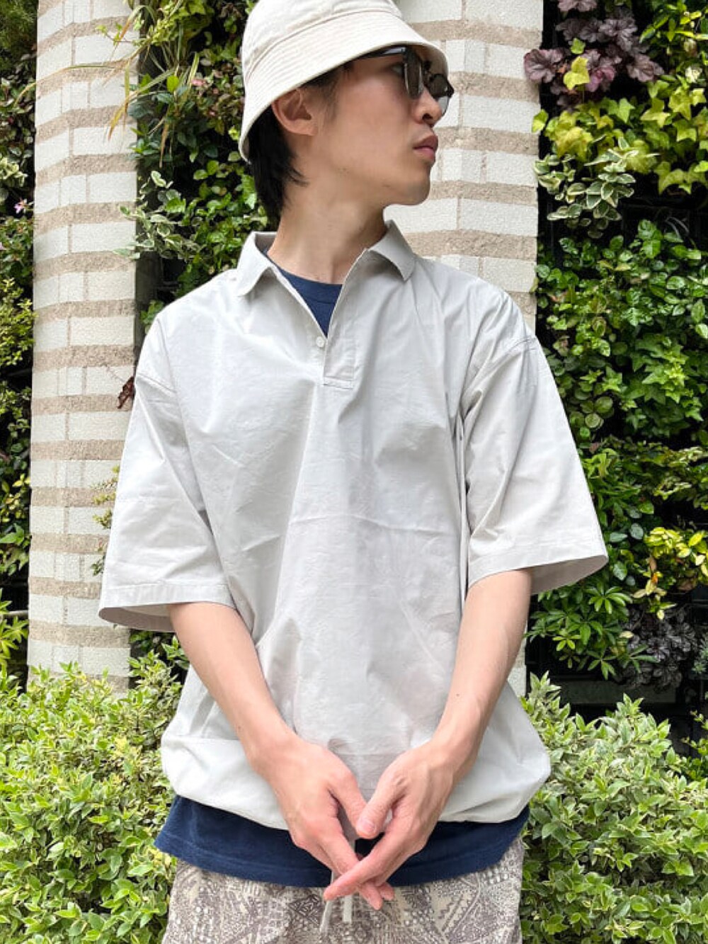 グレー系のポロシャツ、ベージュ系のカーゴパンツ、グリーン系のサンダルを着用したメンズの夏コーディネートの4枚目の写真