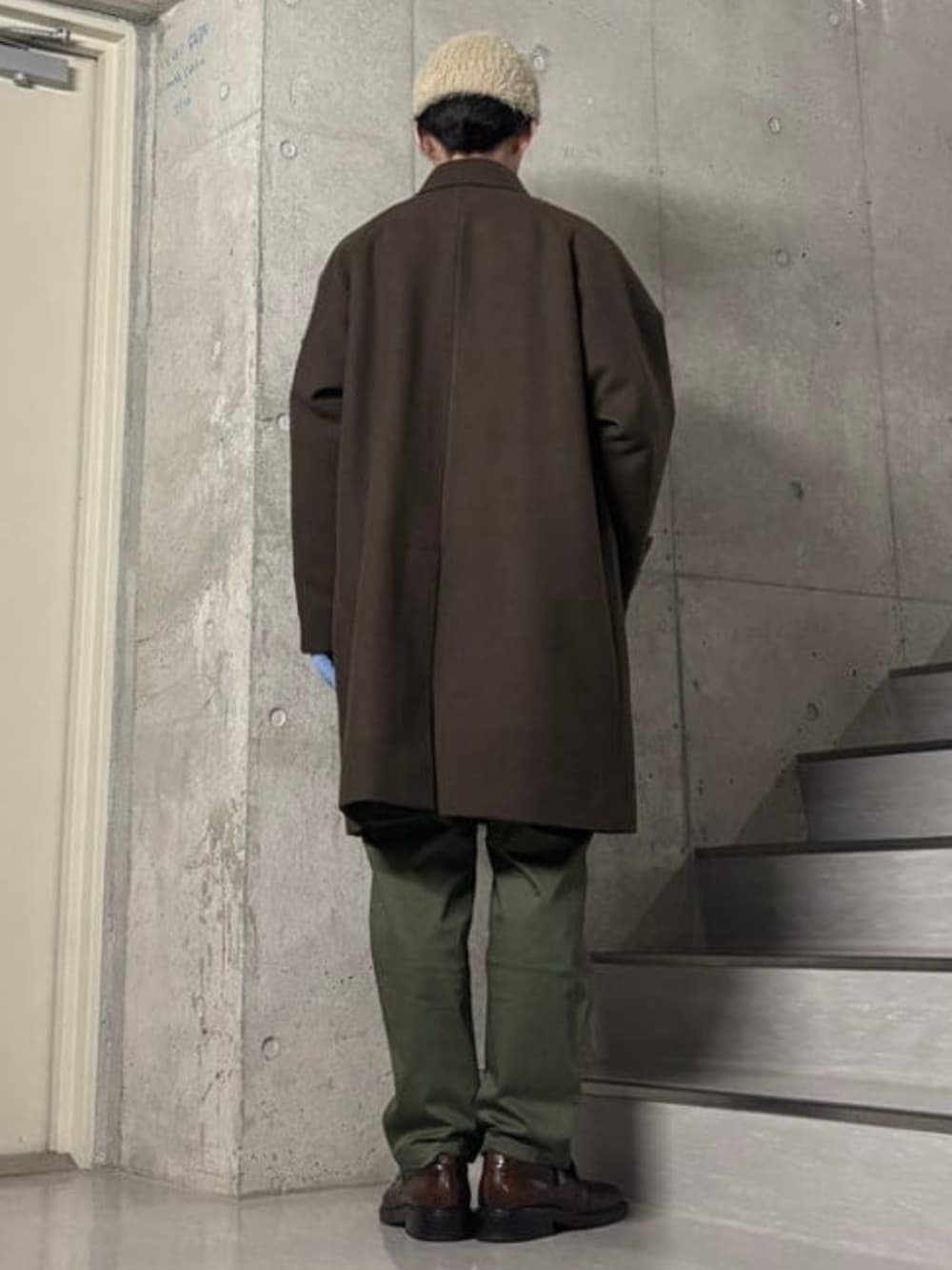 ブラウン系のステンカラーコート、ベージュ系のニット/セーター、グリーン系のその他パンツを着用したメンズの秋コーディネートの2枚目の写真