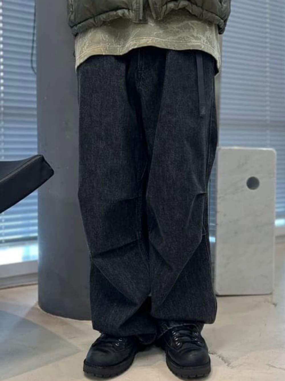 ブラック系のデニムパンツ、グリーン系のベスト、グリーン系のTシャツ/カットソーを着用したメンズの夏コーディネートの4枚目の写真