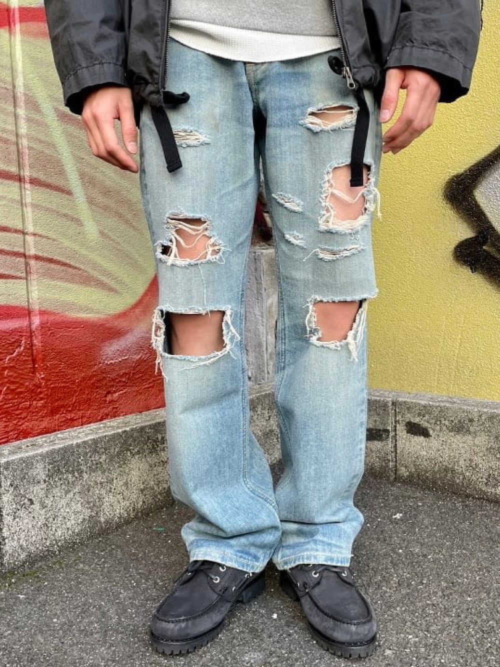 ブラック系のミリタリージャケット、ブルー系のデニムパンツ、グレー系のスウェットを着用したメンズの春コーディネートの4枚目の写真