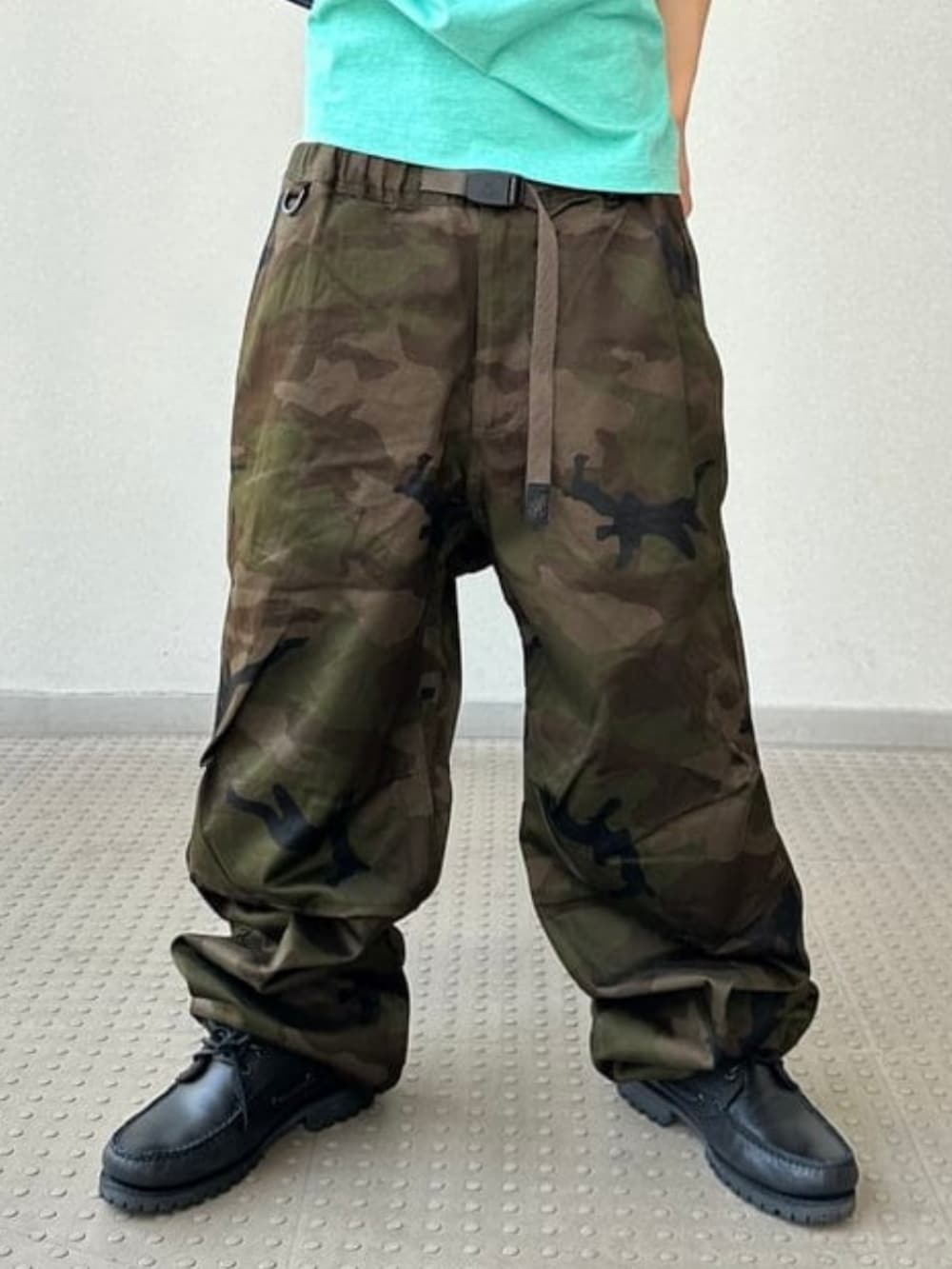 グリーン系のカーゴパンツ、グリーン系のTシャツ/カットソー、ブルー系のショルダーバッグを着用したメンズの夏コーディネートの3枚目の写真