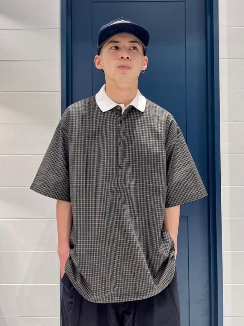 ホワイト系のポロシャツ、ブラック系のシャツ/ブラウス、ブラック系のその他パンツを着用したメンズの春コーディネートの2枚目の写真