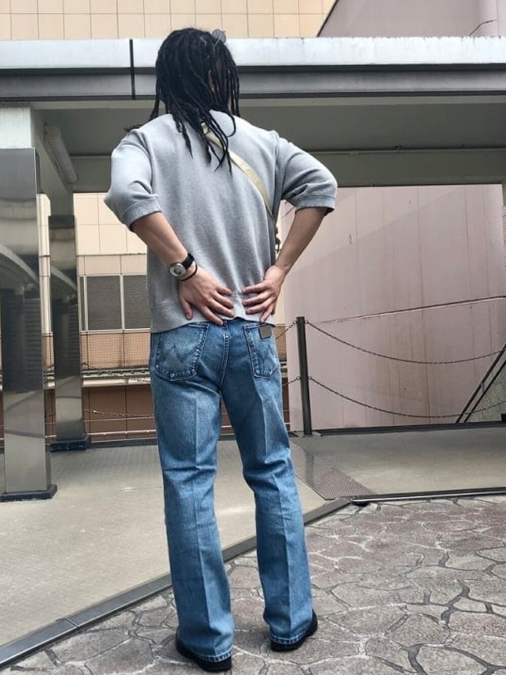 グレー系のスウェット、ブルー系のデニムパンツを着用したメンズの春コーディネートの3枚目の写真