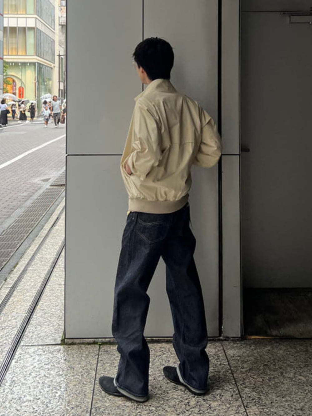 ブルー系のデニムパンツ、ベージュ系のブルゾンを着用したメンズの夏コーディネートの2枚目の写真
