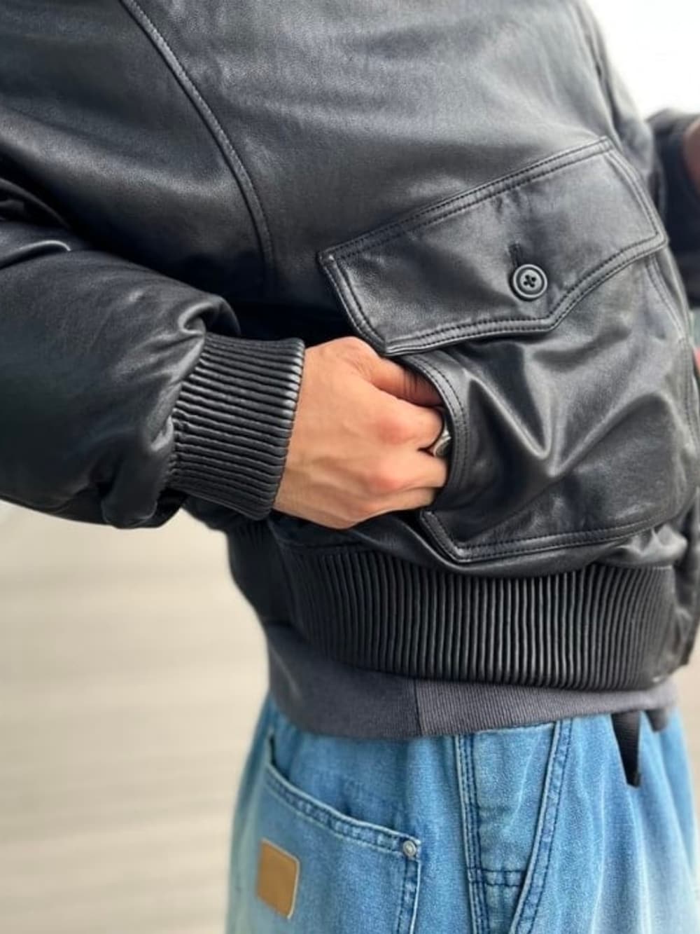 ブラック系のスウェット、ブラック系のダウンジャケット/コート、ブルー系のその他パンツを着用したメンズの秋コーディネートの2枚目の写真