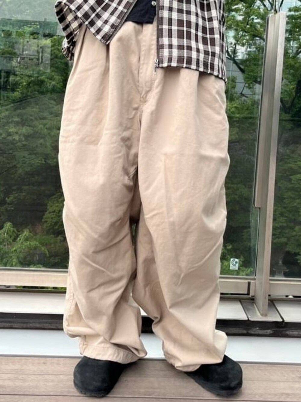 ベージュ系のチノパンツ、ブラック系のサンダルを着用したメンズの夏コーディネートの3枚目の写真