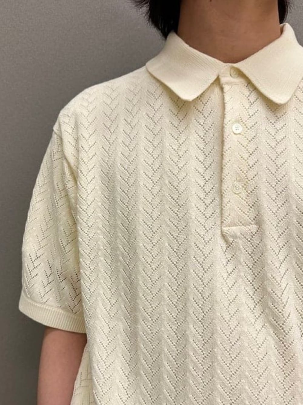 ホワイト系のポロシャツ、ブラック系のスラックス、ブラック系のスニーカーを着用したメンズの夏コーディネートの3枚目の写真