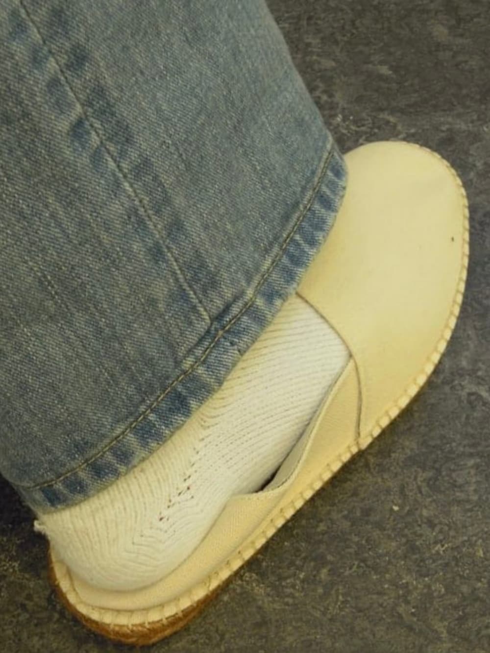 ブルー系のデニムパンツ、ホワイト系のTシャツ/カットソー、ホワイト系のサンダルを着用したメンズの夏コーディネートの3枚目の写真