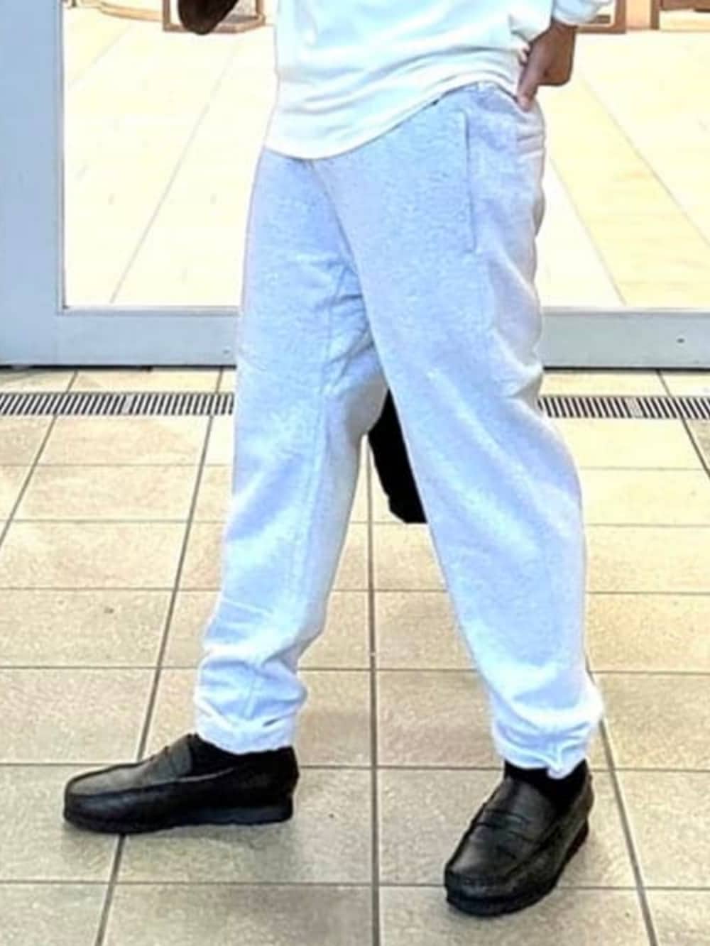 グレー系のスウェットパンツ、ブラック系のダウンジャケット/コート、ホワイト系のTシャツ/カットソーを着用したメンズの秋コーディネートの6枚目の写真