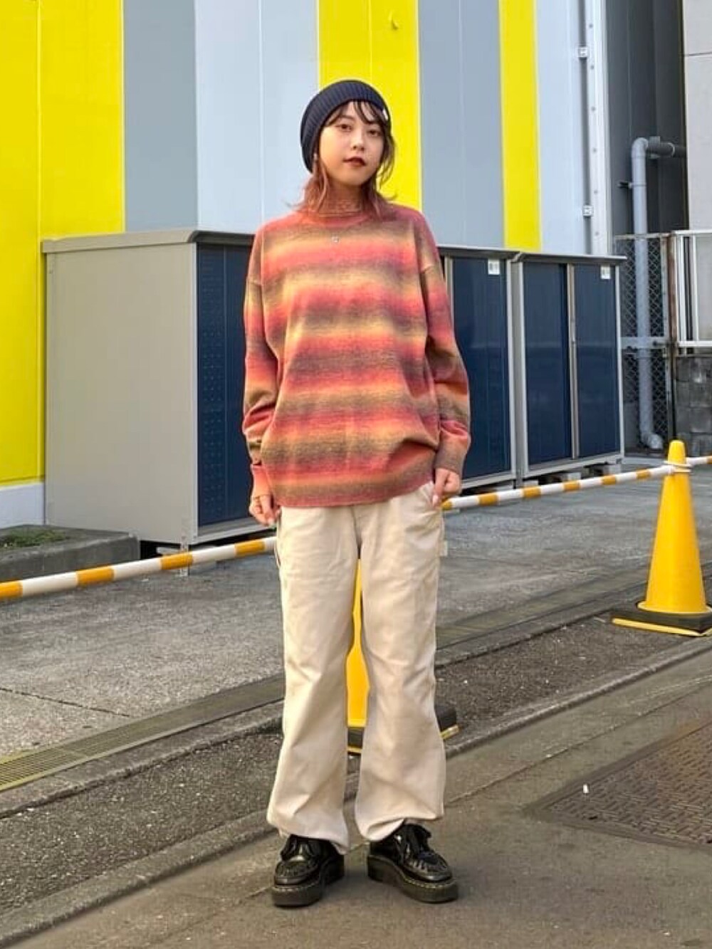 レッド系のニット/セーター、グレー系のベスト、グレー系のその他パンツを着用したレディースの秋コーディネートの3枚目の写真