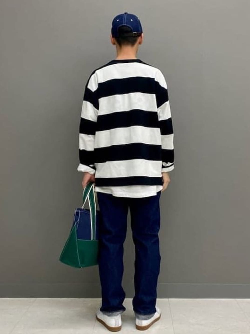 ブラック系のTシャツ/カットソー、ブルー系のデニムパンツ、ホワイト系のスニーカーを着用したメンズの春コーディネートの3枚目の写真