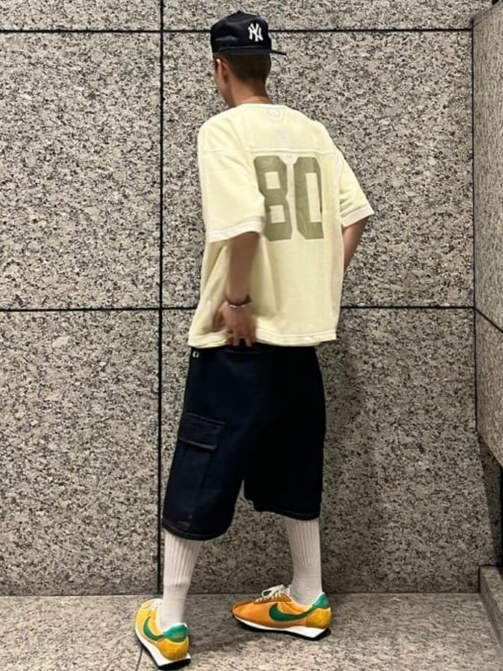 ブルー系のデニムパンツ、イエロー系のTシャツ/カットソー、ベージュ系のTシャツ/カットソーを着用したメンズの夏コーディネートの2枚目の写真