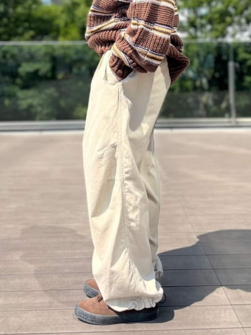 ベージュ系のチノパンツ、ブラウン系のニット/セーターを着用したメンズの夏コーディネートの4枚目の写真