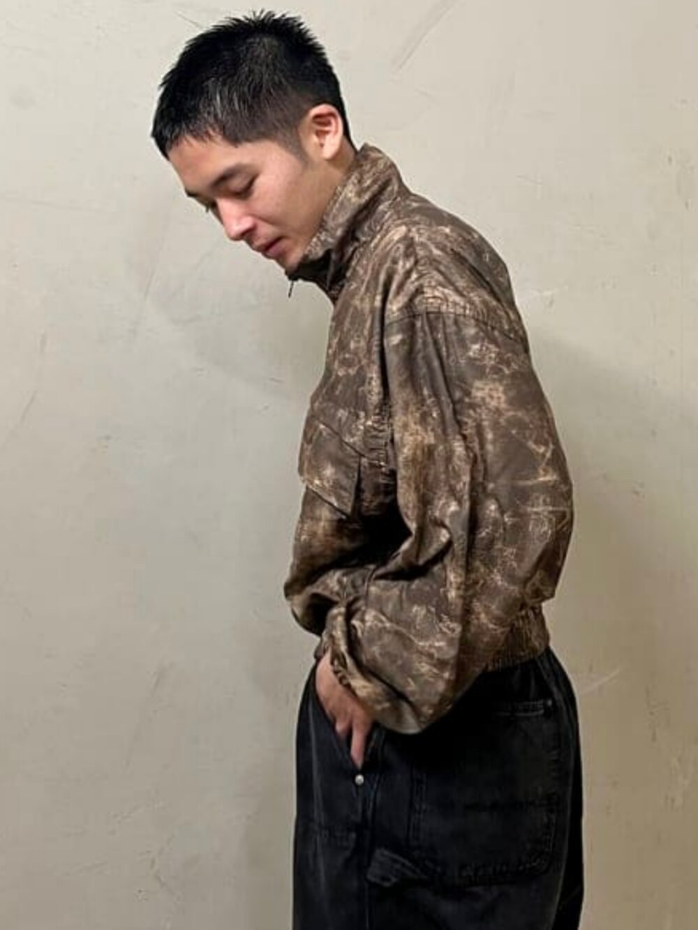 ブラック系のデニムパンツ、ベージュ系のブルゾンを着用したメンズの夏コーディネートの2枚目の写真