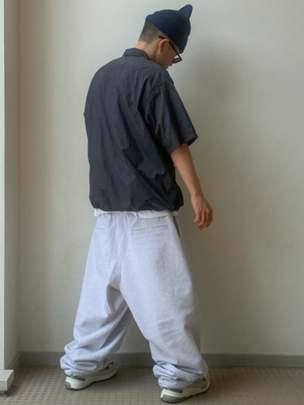 グレー系のスウェットパンツ、ブラウン系のサングラス、ブルー系のニットキャップ/ビーニーを着用したメンズの春コーディネートの3枚目の写真