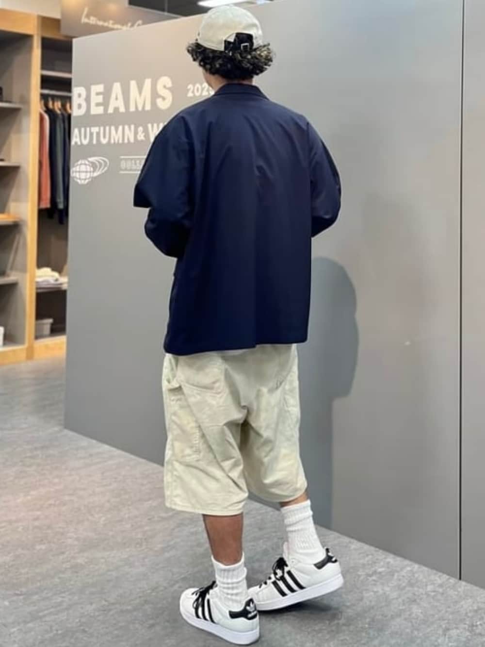 ベージュ系のその他パンツ、ホワイト系のスニーカー、ブルー系のテーラードジャケットを着用したメンズの夏コーディネートの3枚目の写真