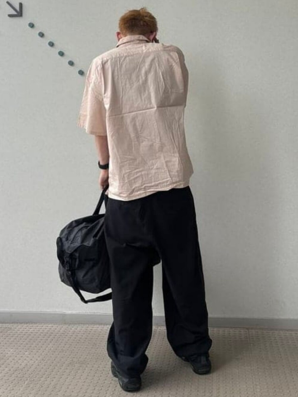 ブラック系のドラムバッグ、ピンク系のシャツ/ブラウス、ブラック系のスラックスを着用したメンズの春コーディネートの3枚目の写真