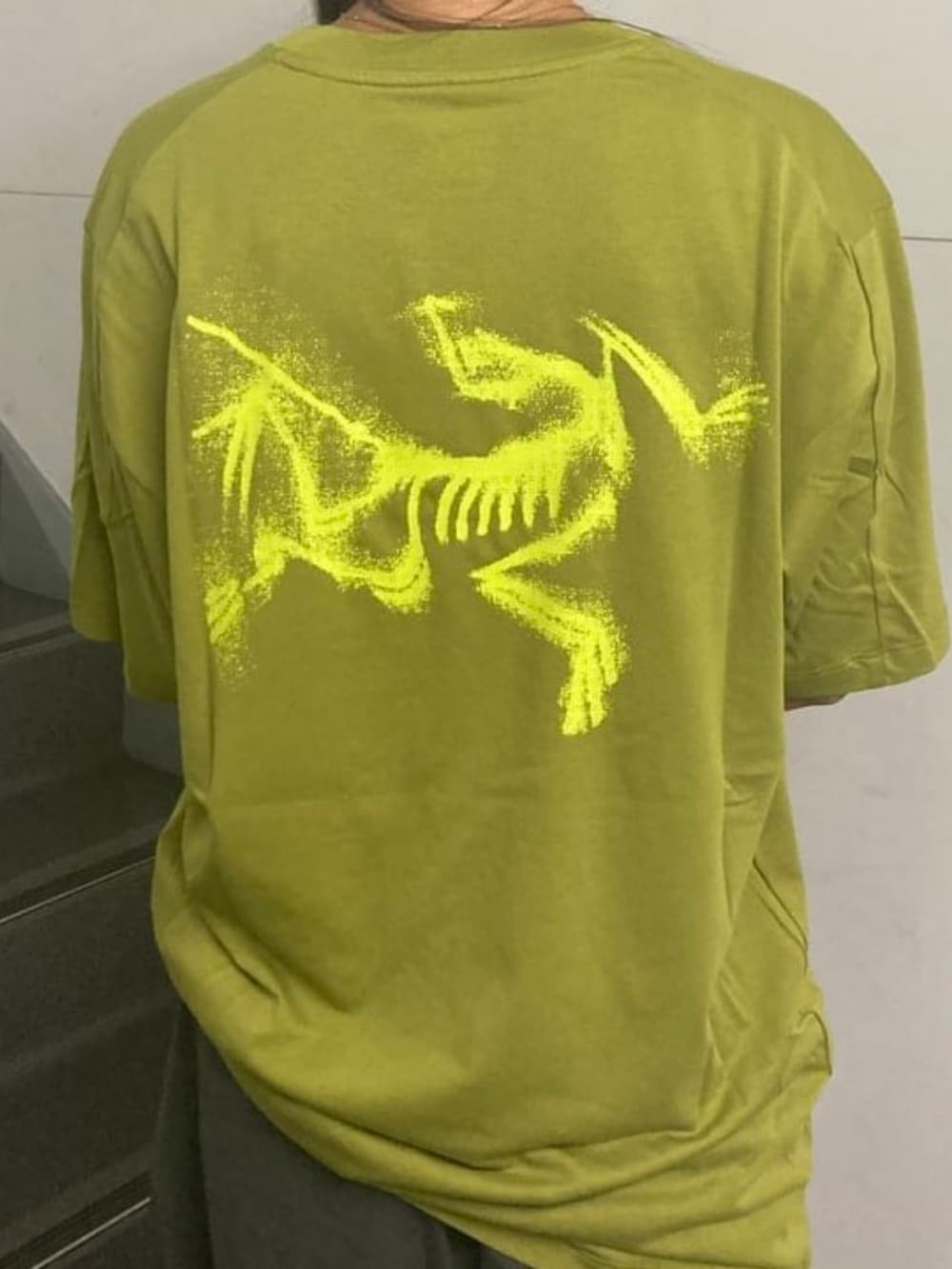 グリーン系のTシャツ/カットソーを着用したレディースの秋コーディネートの2枚目の写真