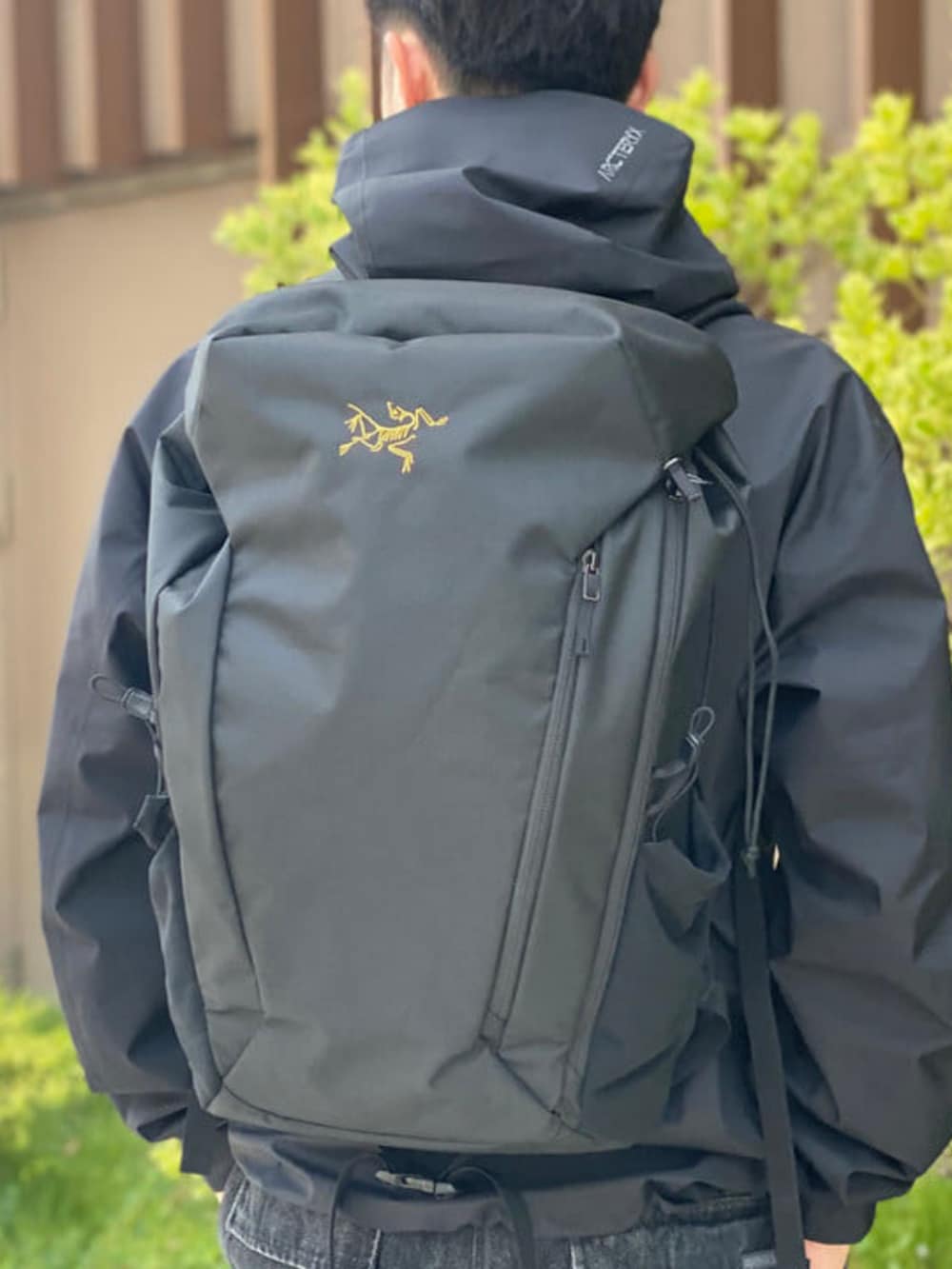 ブラック系のデニムパンツ、ブラック系のバックパック/リュック、ブラック系のブルゾンを着用したメンズの夏コーディネートの2枚目の写真