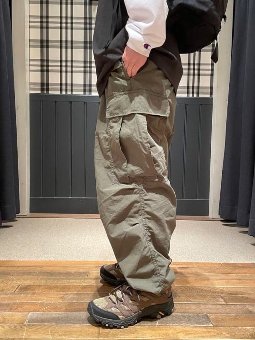 ブラック系のTシャツ/カットソー、グリーン系のカーゴパンツ、グリーン系のスニーカーを着用したメンズの春コーディネートの5枚目の写真