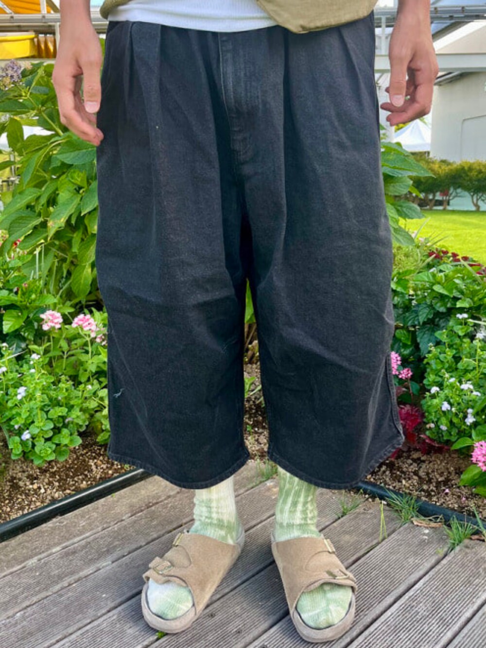 ブラック系のその他パンツ、グリーン系のポロシャツを着用したメンズの夏コーディネートの4枚目の写真