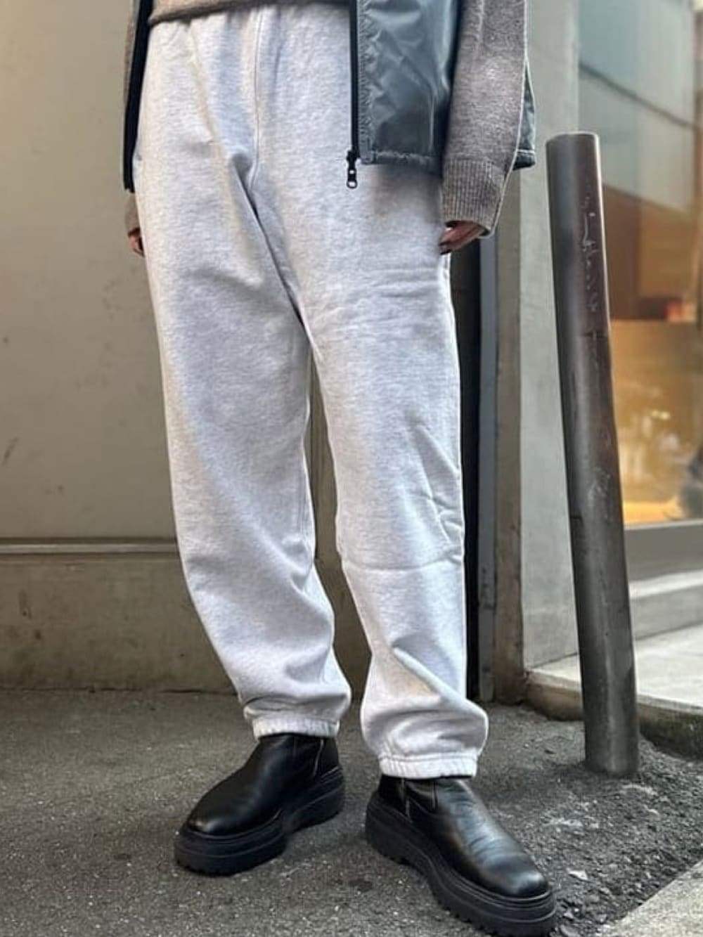 グレー系のスウェットパンツ、ブラウン系のニット/セーター、グレー系のベストを着用したレディースの秋コーディネートの3枚目の写真