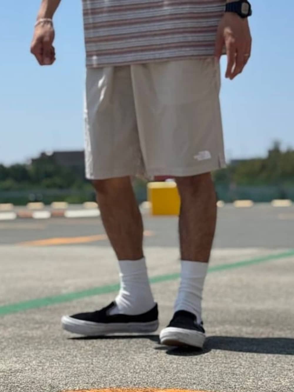 オレンジ系のTシャツ/カットソー、ベージュ系のその他パンツを着用したメンズの夏コーディネートの4枚目の写真