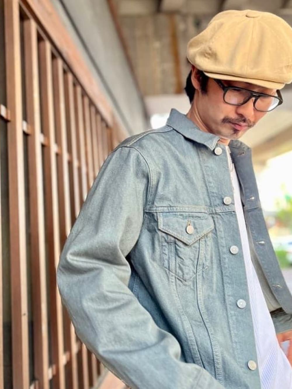 ブルー系のデニムジャケット、ホワイト系のTシャツ/カットソー、ベージュ系のカーゴパンツを着用したメンズの春コーディネートの2枚目の写真