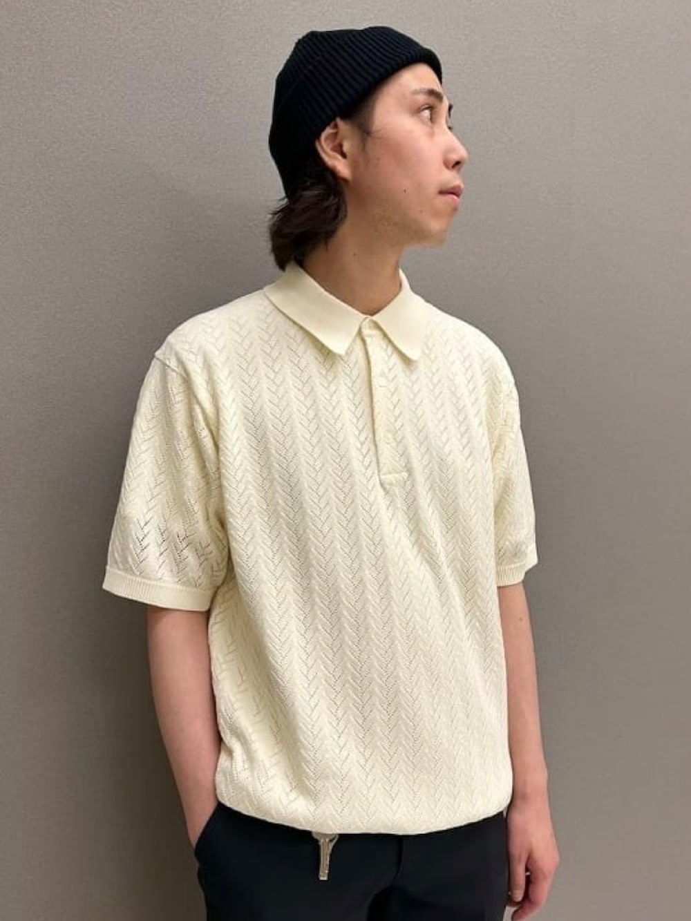 ホワイト系のポロシャツ、ブラック系のスラックス、ブラック系のスニーカーを着用したメンズの夏コーディネートの4枚目の写真