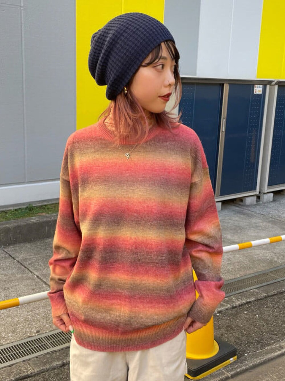 レッド系のニット/セーター、グレー系のベスト、グレー系のその他パンツを着用したレディースの秋コーディネートの4枚目の写真