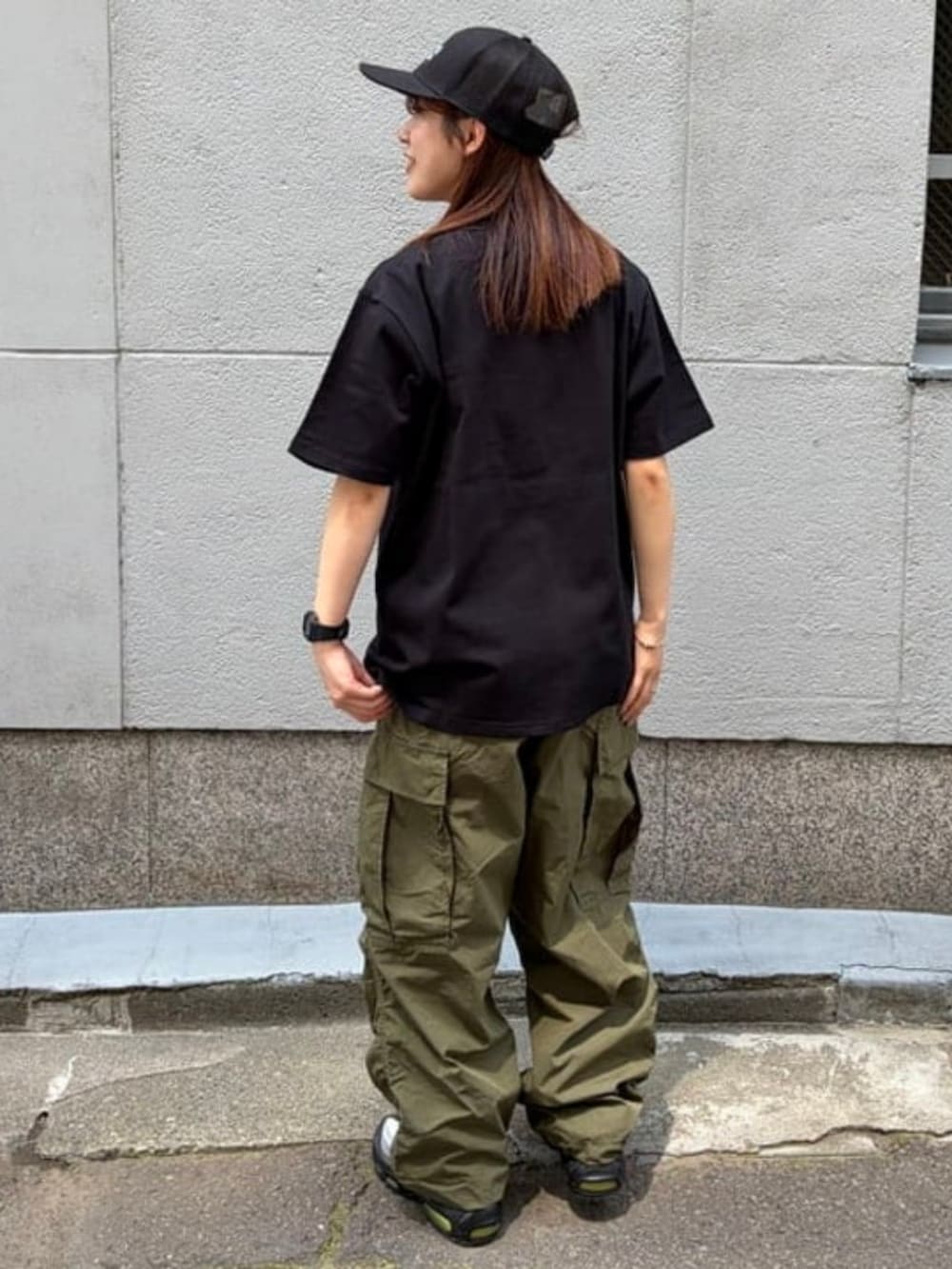 グリーン系のカーゴパンツ、ブラック系のTシャツ/カットソーを着用したメンズの夏コーディネートの2枚目の写真